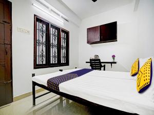 a bedroom with a bed and a window and a table at Kabas Lodge in Ernakulam