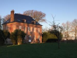 a large brick house with a black roof at Le Clos du bas hameau in Canouville