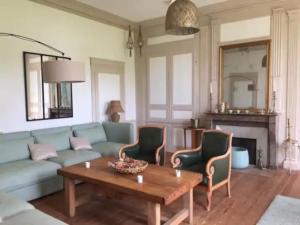 a living room with a couch and a table at Le Clos du bas hameau in Canouville