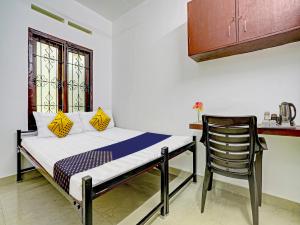 um quarto com uma cama e uma cadeira em Kabas Lodge em Ernakulam