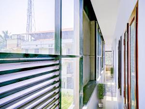 a glass walled hallway with a view of a building at Kabas Lodge in Ernakulam