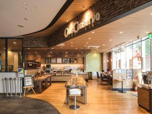 a fast food restaurant with people sitting at tables at Vessel Inn Shigamoriyamaekimae in Moriyama