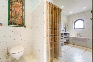 uma casa de banho com WC e uma pintura na parede em Les Herbes Folles em Canouville