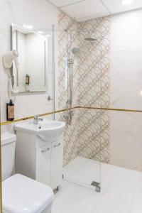 um banheiro com chuveiro, vaso sanitário e pia em Art Hotel Simona em Sófia mais 24 fotografias