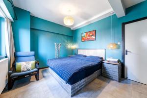 Banma Family All-Suite B&B في شيان: غرفة نوم بجدران زرقاء وسرير وكرسي