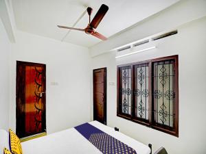 ein Schlafzimmer mit einem Bett und zwei Fenstern in der Unterkunft Kabas Lodge in Ernakulam