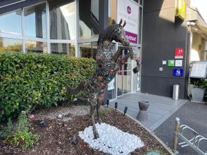 une statue d'un dragon devant un bâtiment dans l'établissement Hotel Restaurant Du Parc Saumur Logis Elégance, à Saumur