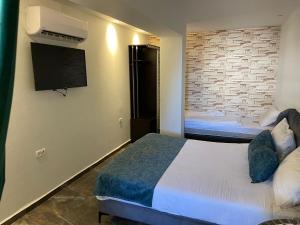 Habitación de hotel con 2 camas y TV de pantalla plana. en Lago Suites Hotel en Jerusalén