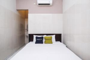 una camera con un letto con due cuscini sopra di Urbanview Syariah Wisma Wongso Borobudur a Magelang