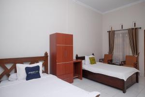 Postelja oz. postelje v sobi nastanitve Urbanview Syariah Wisma Wongso Borobudur