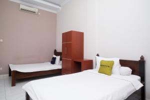 Postelja oz. postelje v sobi nastanitve Urbanview Syariah Wisma Wongso Borobudur