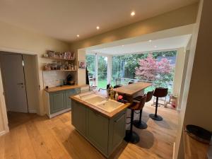 eine Küche mit einer Theke und einem großen Fenster in der Unterkunft Charmante maison familiale in Kraainem