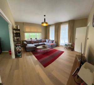 ein Wohnzimmer mit Sofa und Tisch in der Unterkunft Charmante maison familiale in Kraainem