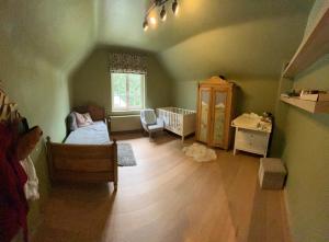 ein Schlafzimmer mit einem Bett und einem Kinderbett in einem Zimmer in der Unterkunft Charmante maison familiale in Kraainem + 3 Fotos