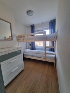 1 Schlafzimmer mit 2 Etagenbetten und einem Spiegel in der Unterkunft Ammophila 1 in Egmond aan Zee