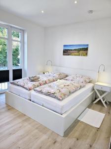 um quarto branco com 2 camas e uma secretária em Komfort-Ferienwohnung Zur Alten Post em Wildeshausen