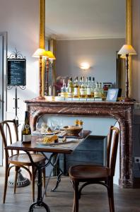 una mesa con 2 sillas y un bar con bebidas en Golf de Rebetz- Domaine de Rebetz, en Chaumont-en-Vexin