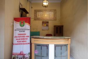 una habitación con un mostrador y un cartel en la pared en Urbanview Syariah Wisma Wongso Borobudur en Magelang
