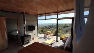 uma sala de estar com um sofá e uma grande janela em Gran Vista y Tranquilidad em Villa Serrana