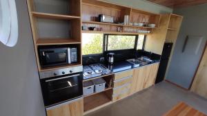 a small kitchen with a stove and a microwave at Gran Vista y Tranquilidad in Villa Serrana