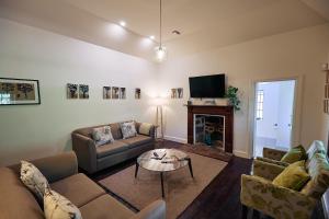 sala de estar con sofás, TV y chimenea en Jacobs Estate Cottage en Rowland Flat