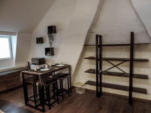 a room with a table and a shelf in a attic at L'Abri in Ypres