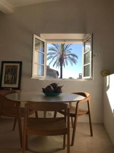a table in a room with a palm tree in the window at VILLAGE - DUPLEX lumineux avec vue magnifique sur les toits in Saint-Tropez