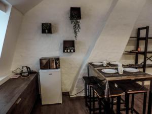 a small kitchen with a table and a refrigerator at L'Abri in Ypres