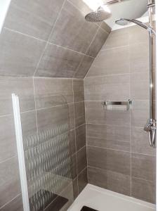 a bathroom with a shower with gray tile at L'Abri in Ypres