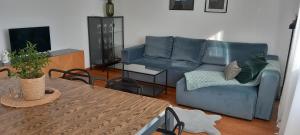 salon z niebieską kanapą i stołem w obiekcie AnJa Apartment w mieście Sandomierz