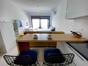 a kitchen with two chairs and a wooden table at Studio Alev POOLview-CaesarResortSpa(North Cyprus) in Perivolia tou Trikomou