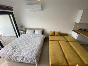 a bedroom with a bed and a couch in it at Studio Alev POOLview-CaesarResortSpa(North Cyprus) in Perivolia tou Trikomou