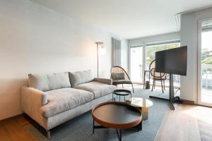uma sala de estar com um sofá e uma televisão em Hotel Aare Thun em Thun