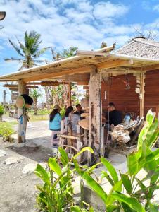 a group of people sitting in a shack at Sirus Base Camp Tagulandang in Kisihang