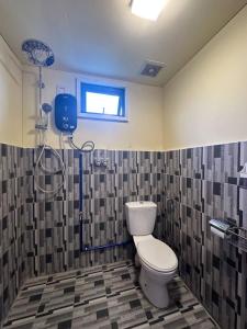 een badkamer met een toilet en een douche bij GEORGE ADVENTURE BASE BUNDU TUHAN 