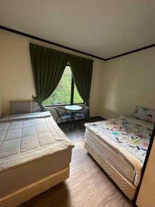 een slaapkamer met 2 bedden, een tafel en een raam bij GEORGE ADVENTURE BASE BUNDU TUHAN 
