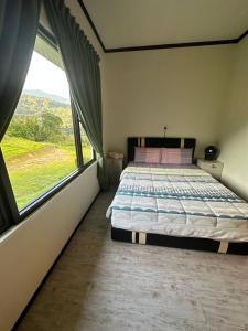 a bedroom with a bed and a large window at GEORGE ADVENTURE BASE BUNDU TUHAN 