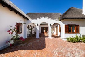 een groot wit huis met een stenen binnenplaats bij Laborie Estate in Paarl