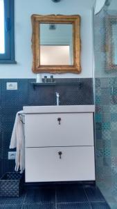 y baño con lavabo blanco y espejo. en Avocado B&B Beyond, en Giardini Naxos