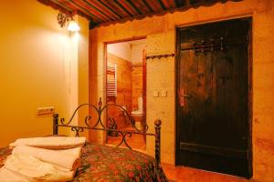 a bedroom with a bed and a door to a bathroom at Alaca Cave Suites in Goreme