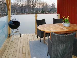 a patio with a table and chairs and a grill at 6 person holiday home in ALSTERBRO in Kättilstorp