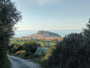 a dirt road with a village on top of a hill at La Petronilla in Castelsardo