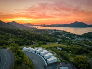 尾道市にあるLEMON FARM GLAMPING simanamiの夕日を背景にした道路の空中