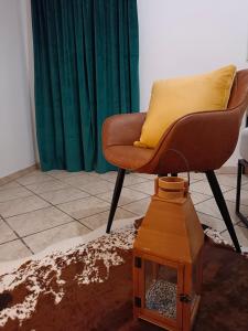 a chair with a yellow pillow and a dog house at Vichome in Catania