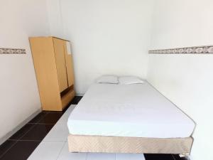 Tempat tidur dalam kamar di Bumi Merpati Residence Makassar Mitra RedDoorz