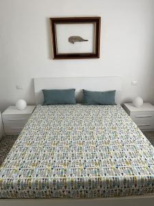 a bed in a bedroom with a picture on the wall at Il Pesce di Legno in Livorno