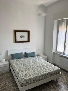 een witte slaapkamer met een bed met blauwe kussens bij Il Pesce di Legno in Livorno