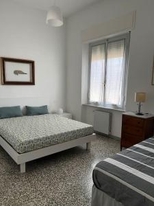 a white bedroom with a bed and a window at Il Pesce di Legno in Livorno