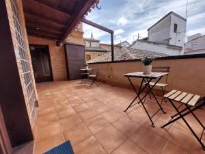 a patio with a table and chairs on a balcony at ToledoAloja - Estudio en Toledo in Toledo