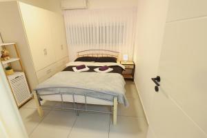 1 dormitorio con 1 cama con 2 almohadas en הטרקלין של שלמה. דירה יפה וחדשה 5 דקות נסיעה מהים en Ashkelon